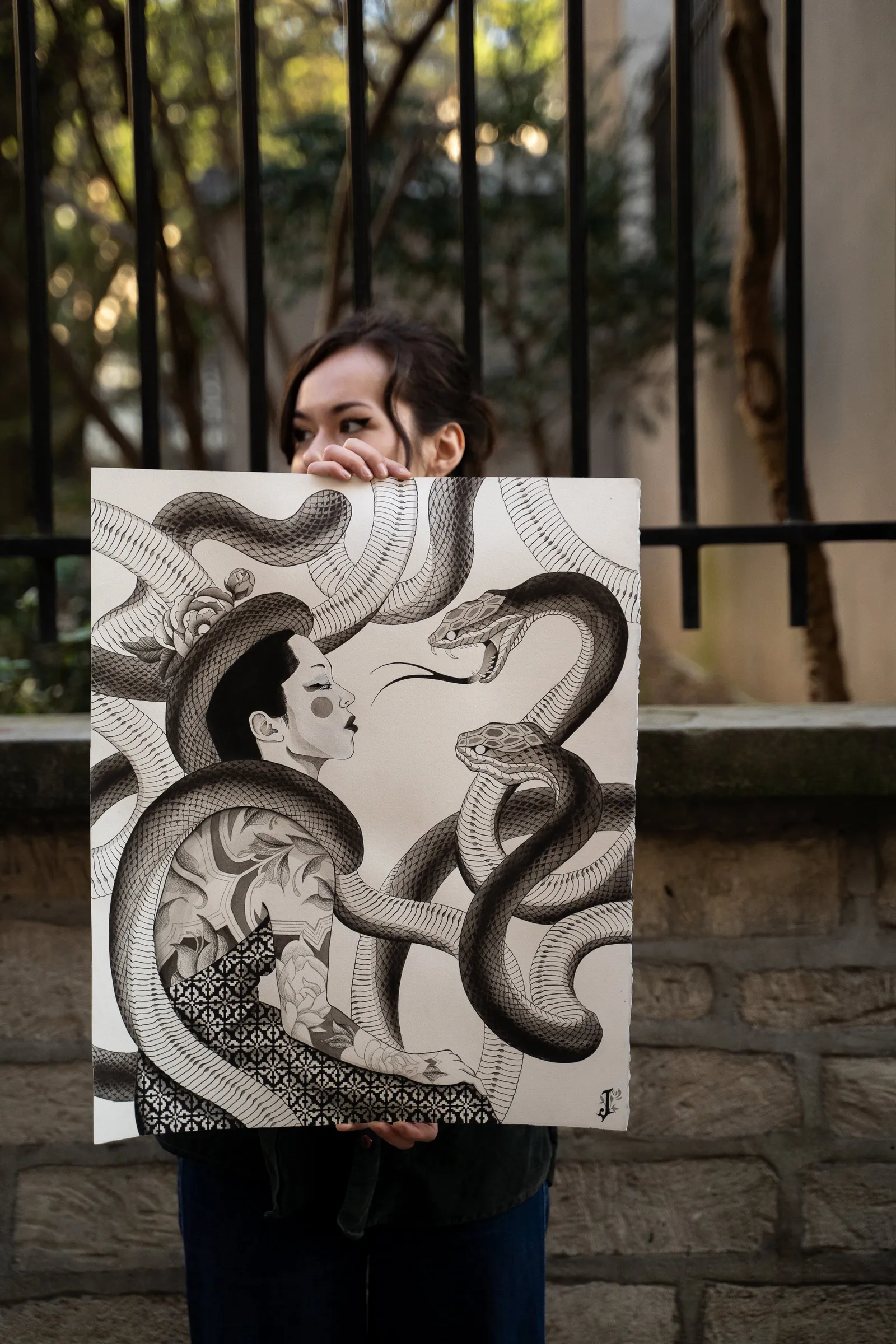 Joy holding up the whole painting outdoors, women's faces among huge coiled snakes in black and grey