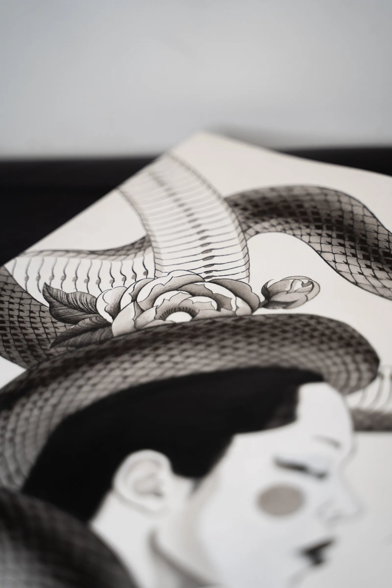 Detail: a woman's face beneath a snake's coil
