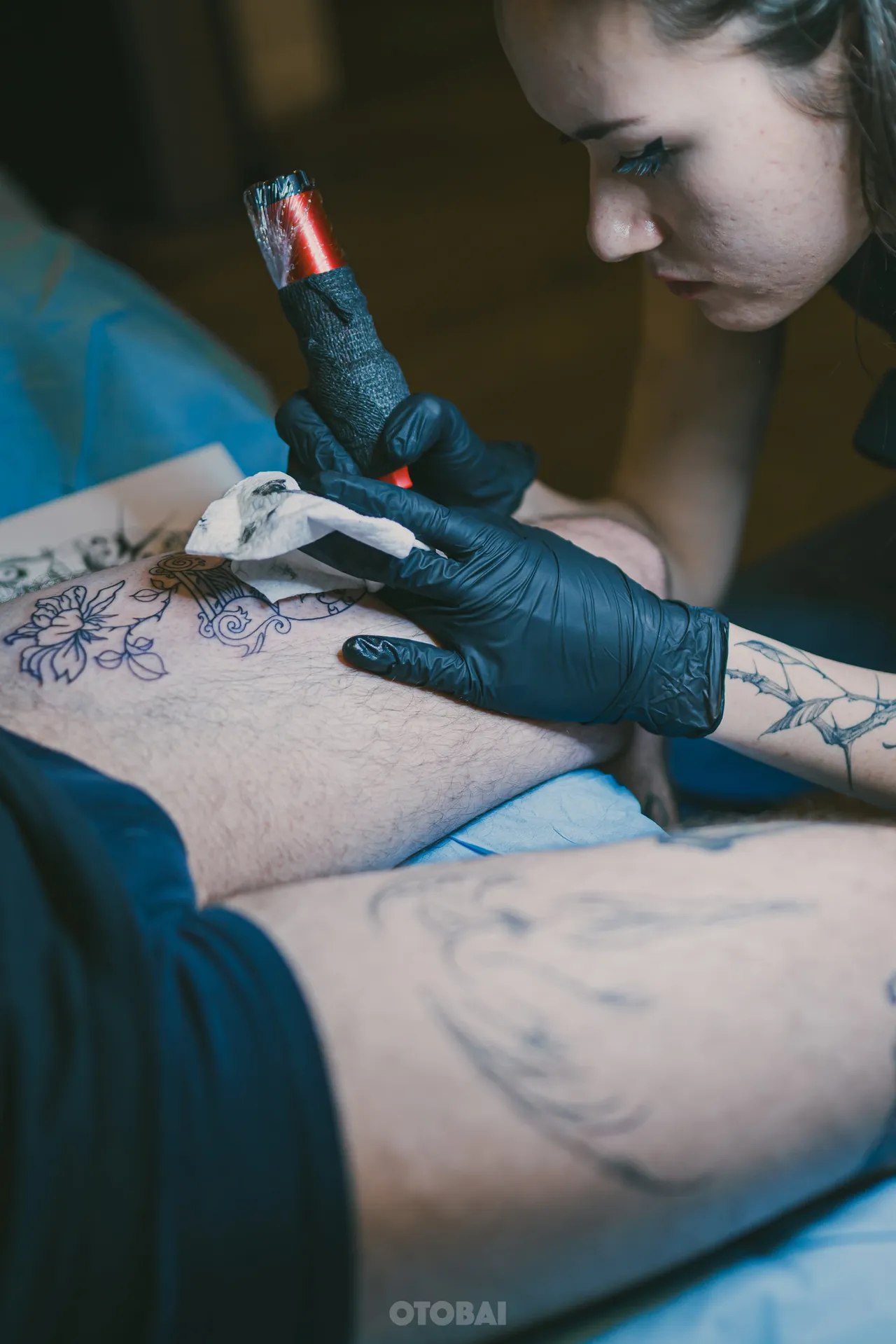 Joy shading a tattoo, her eyes on the needle